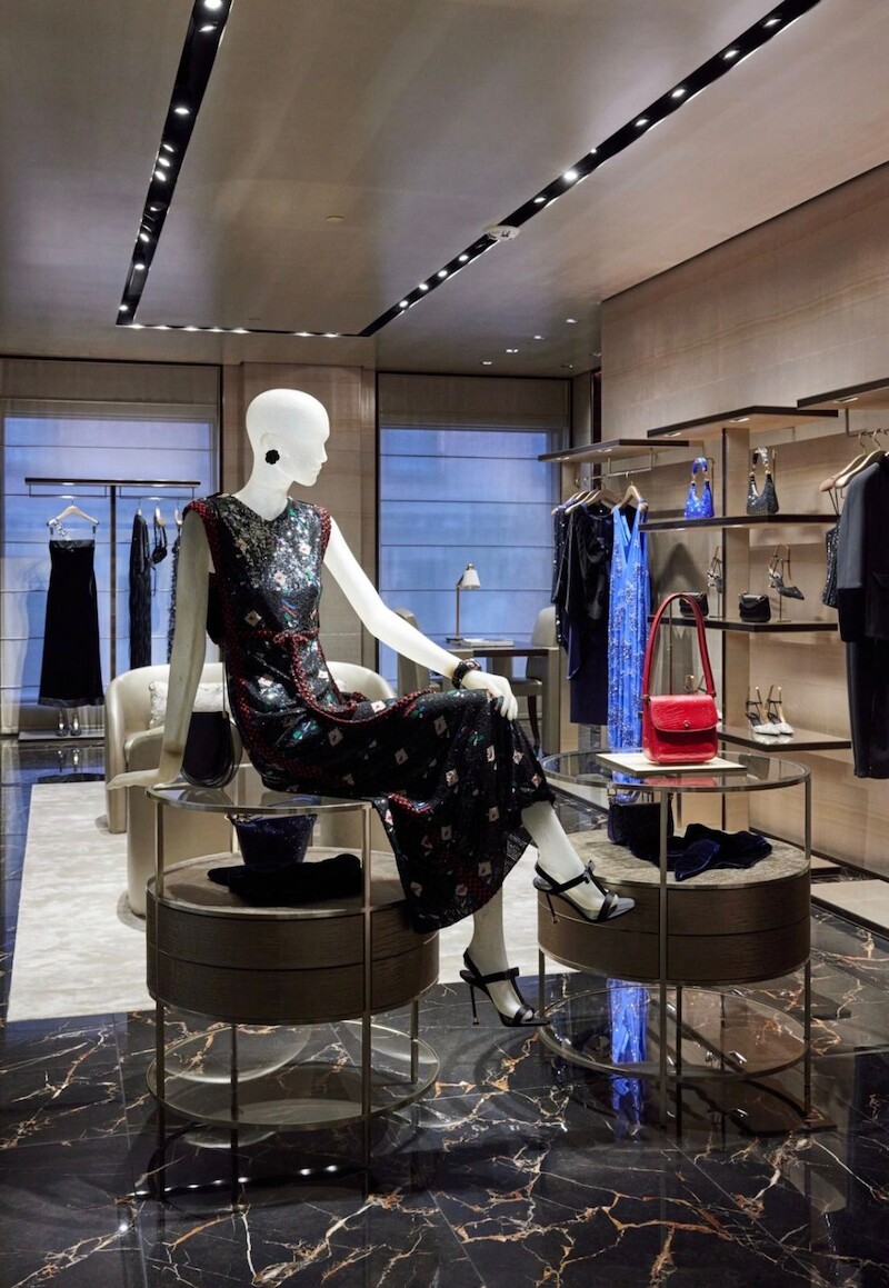 Styled mannequin and merchandised accessories wall in an Armani store